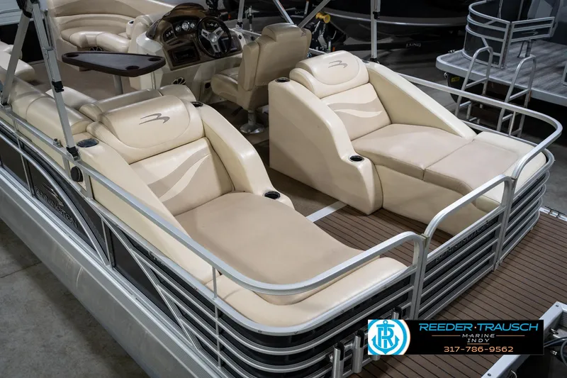 Slide: The Image of 2014 Bennington 2275GCW pontoon boat with luxurious seating and sleek design in a showroom. - 14