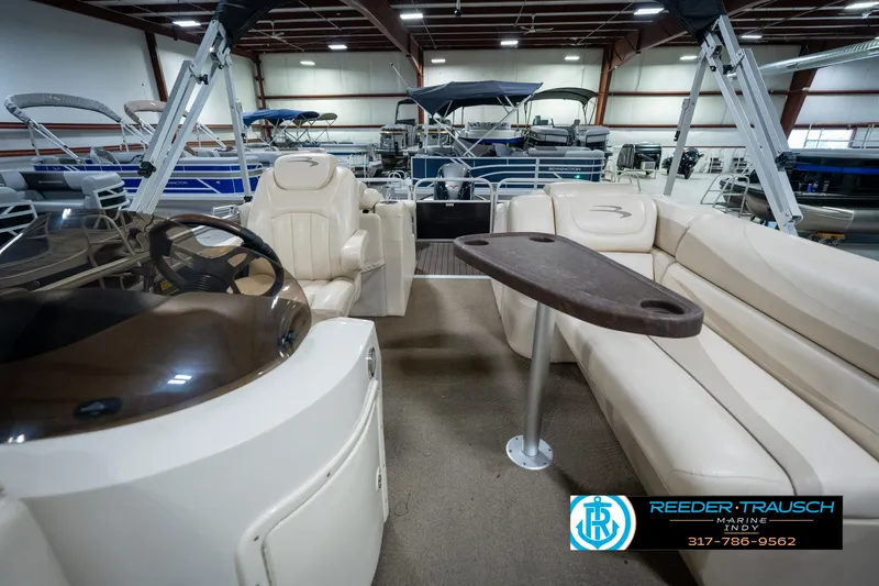 Slide: The Image of 2014 Bennington 2275GCW pontoon boat interior with beige seating and cup holders. - 16
