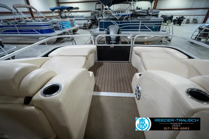 Slide: The Image of 2014 Bennington 2275GCW pontoon boat interior with seating and table in showroom. - 17