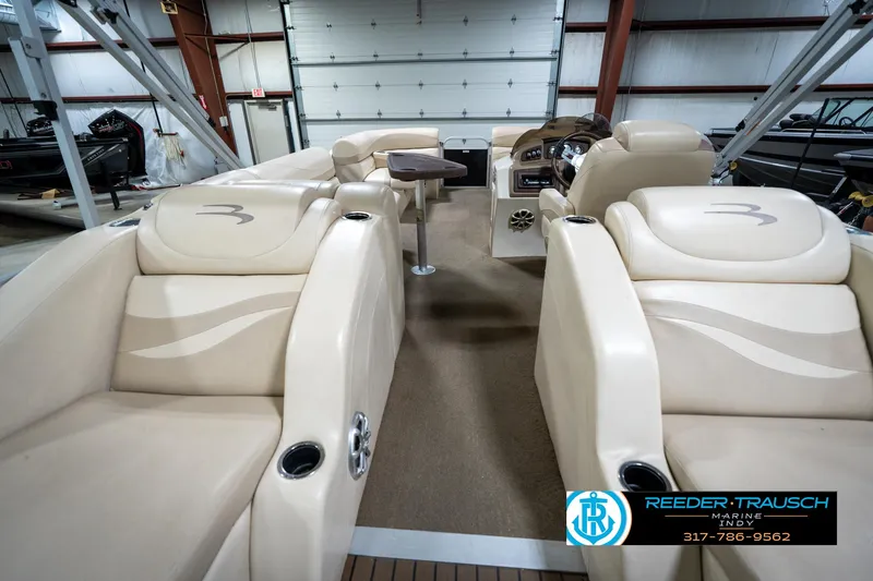 Slide: The Image of 2014 Bennington 2275GCW pontoon boat interior with beige seating and wood-style flooring. - 18