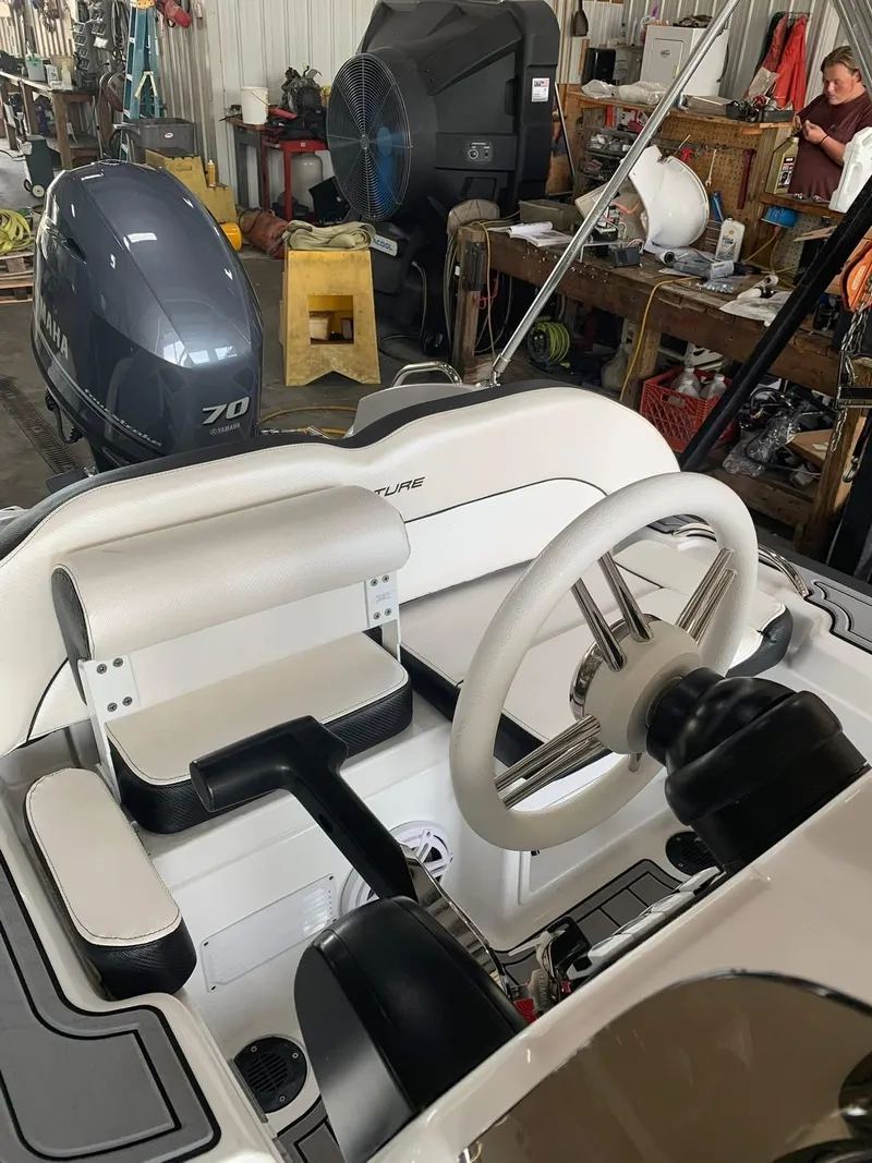 Slide: The Image of 2021 Walker Bay Venture 14 boat interior with steering wheel in a workshop setting. - 3