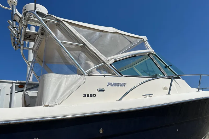 Slide: The Image of 2002 Pursuit 2860 Denali boat with canopy against clear blue sky. - 10