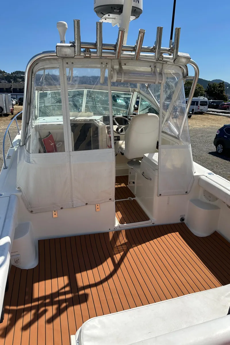 Slide: The Image of 2002 Pursuit 2860 Denali boat with spacious deck and seating, docked outdoors. - 13