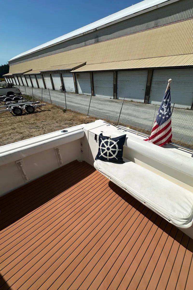 Slide: The Image of 2002 Pursuit 2860 Denali boat deck with cushion, nautical pillow, and American flag. - 14