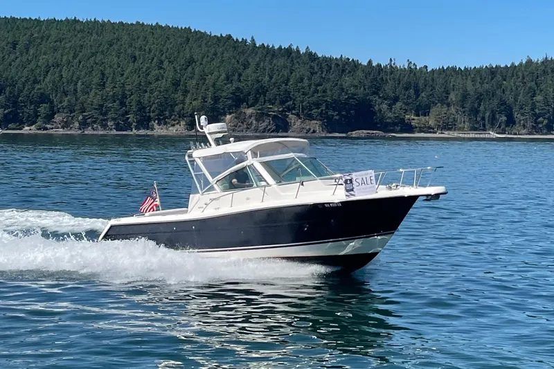 Slide: The Image of 2002 Pursuit 2860 Denali boat for sale cruising on a scenic lake. - 2