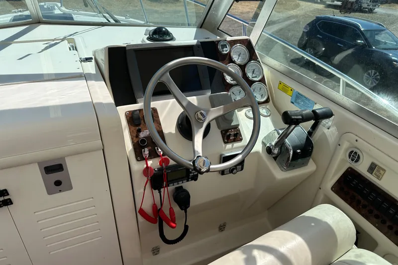 Slide: The Image of 2002 Pursuit 2860 Denali boat helm with steering wheel, gauges, and controls. - 21