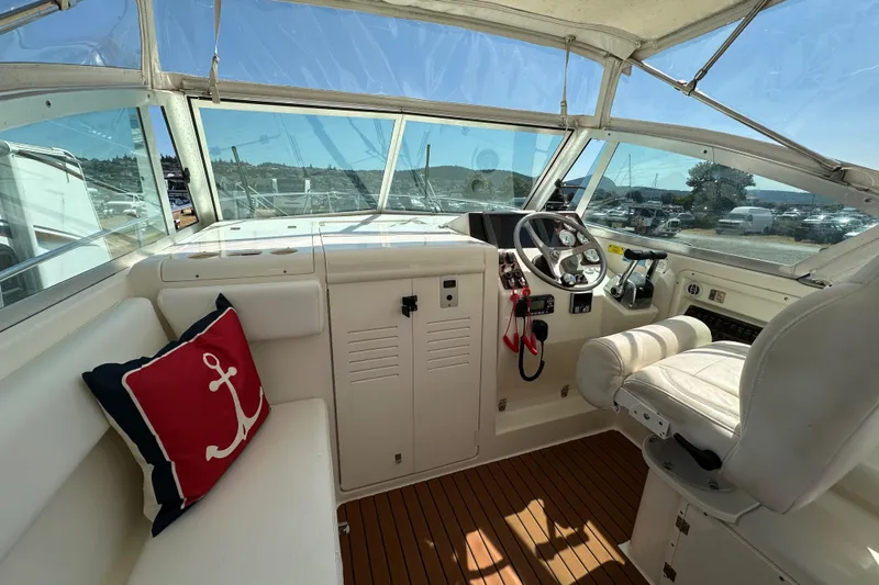 Slide: The Image of 2002 Pursuit 2860 Denali boat interior with steering wheel and anchor-themed pillow. - 22
