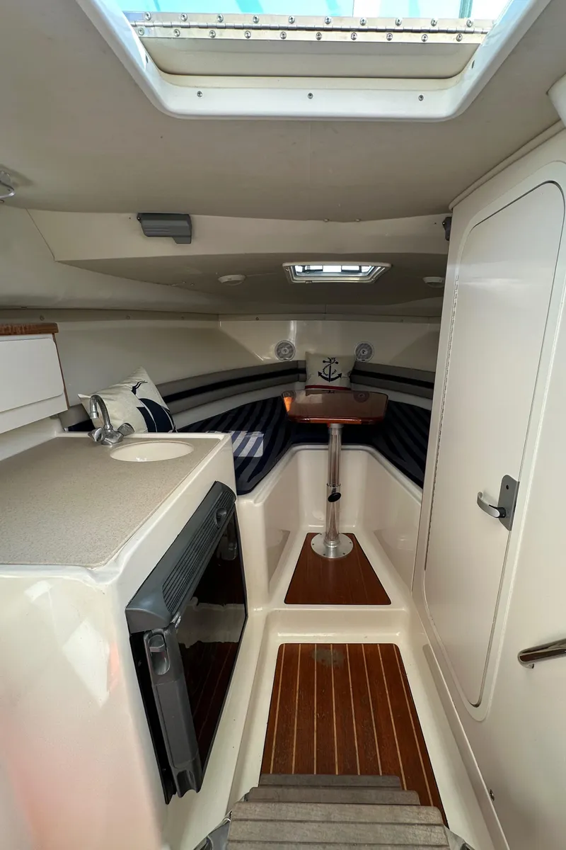 Slide: The Image of 2002 Pursuit 2860 Denali cabin interior with skylight, kitchenette, and seating area. - 31