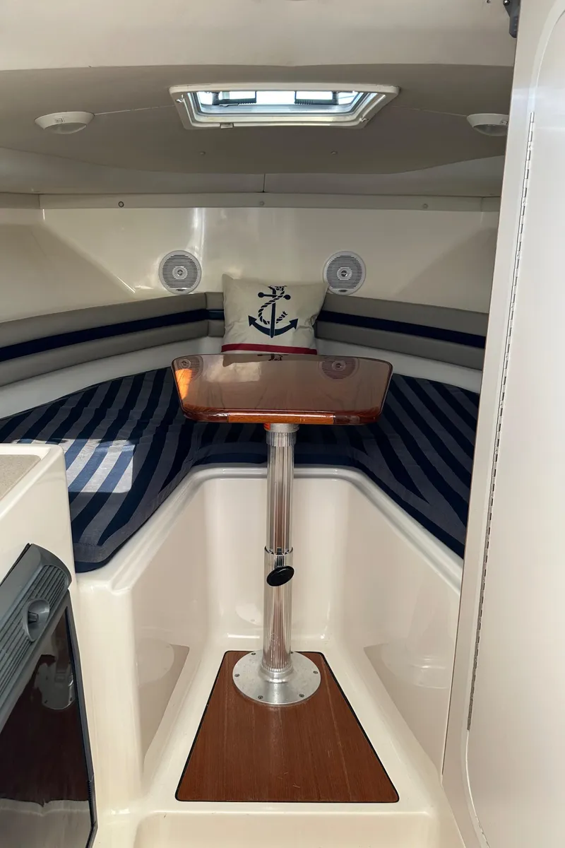 Slide: The Image of 2002 Pursuit 2860 Denali cabin interior with striped seating and anchor-themed pillow. - 32