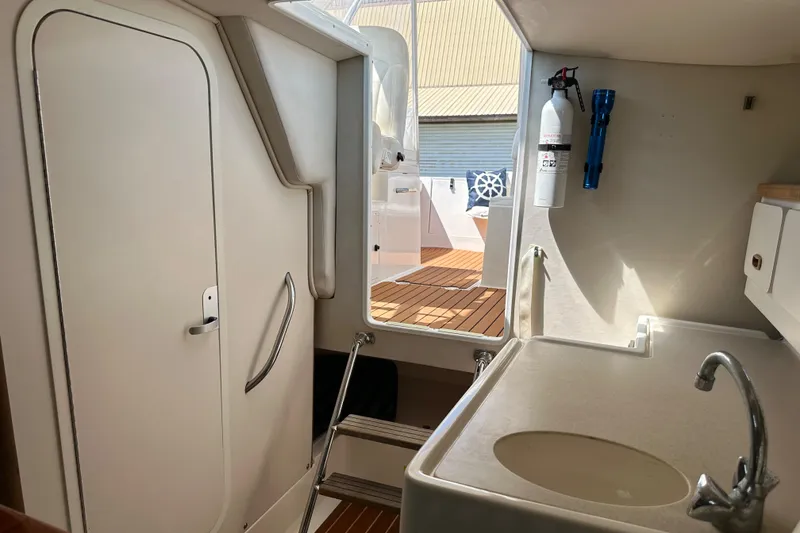 Slide: The Image of Interior of 2002 Pursuit 2860 Denali boat, featuring a compact bathroom and sink area. - 34