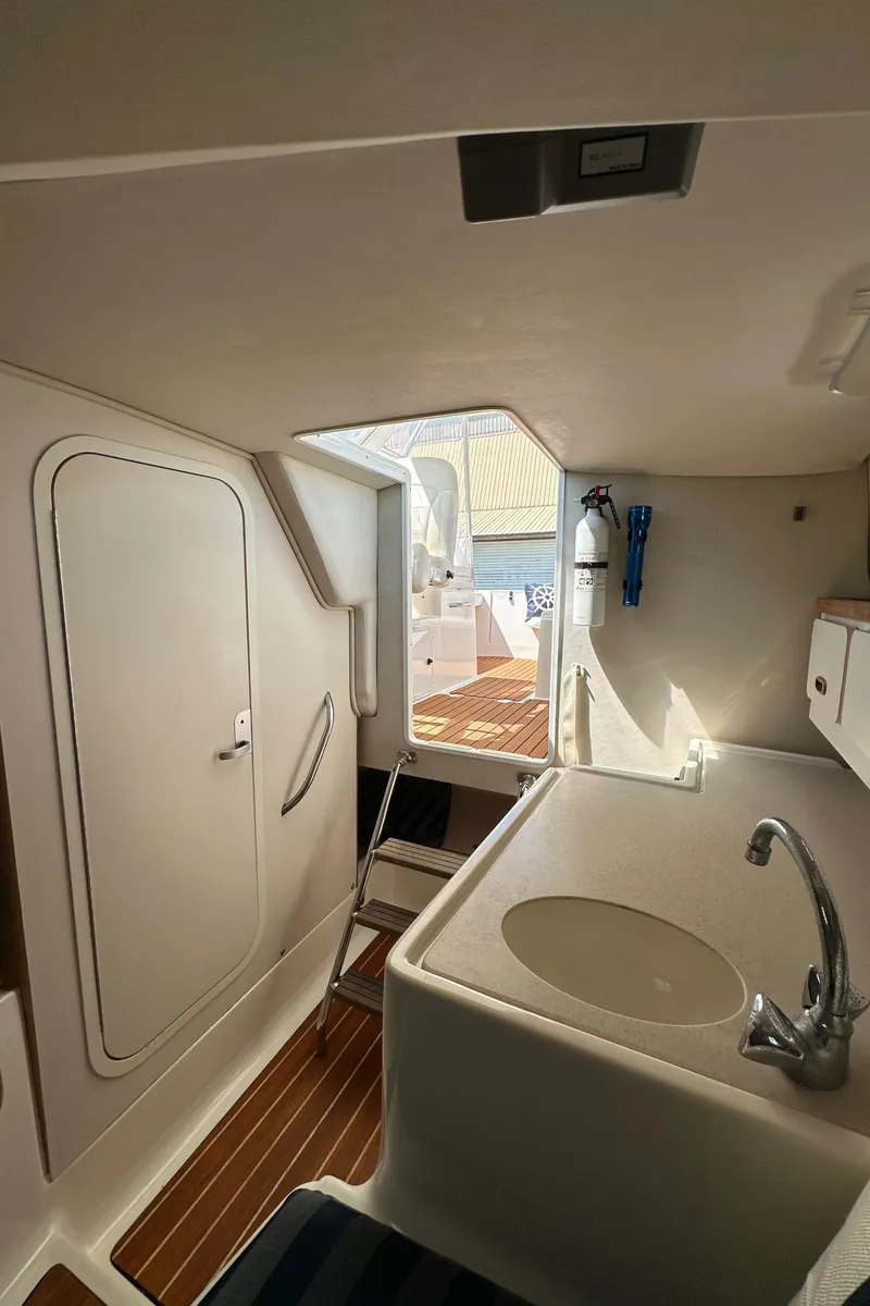 Slide: The Image of Interior of 2002 Pursuit 2860 Denali boat with sink and wooden flooring. - 35