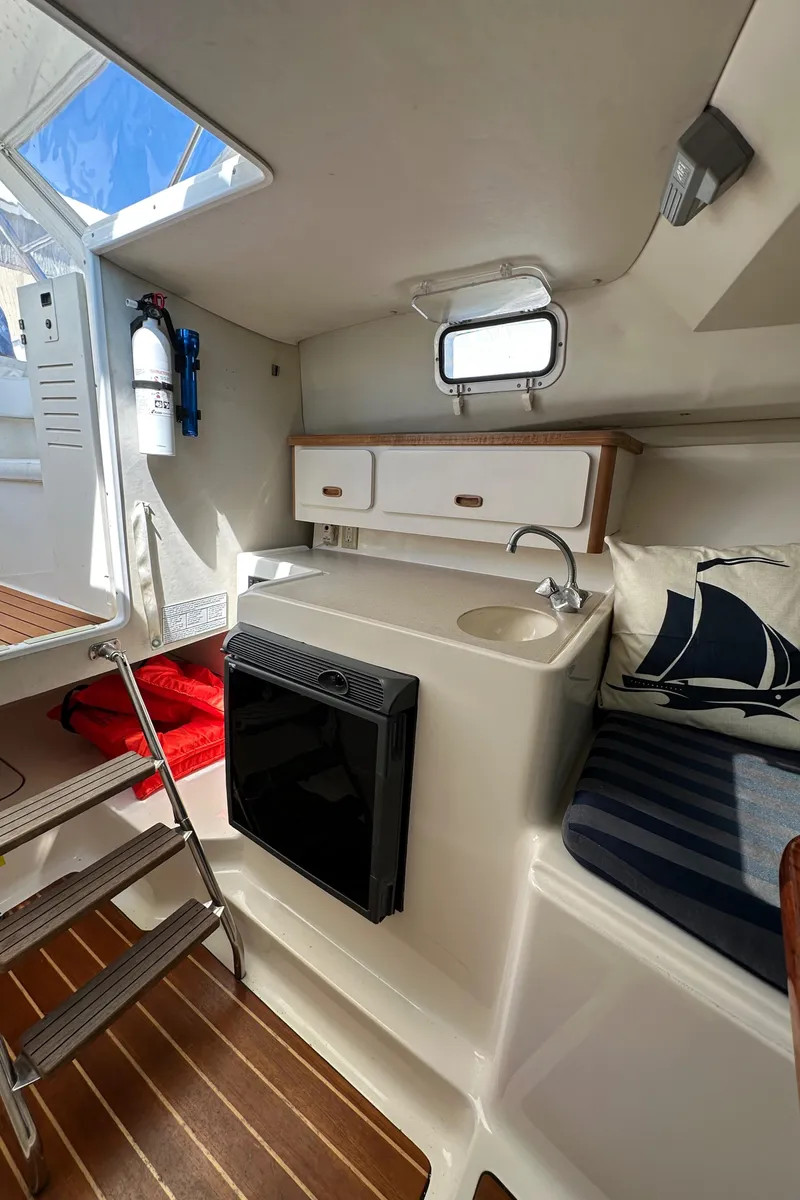 Slide: The Image of Interior of 2002 Pursuit 2860 Denali boat with kitchenette and seating area. - 36