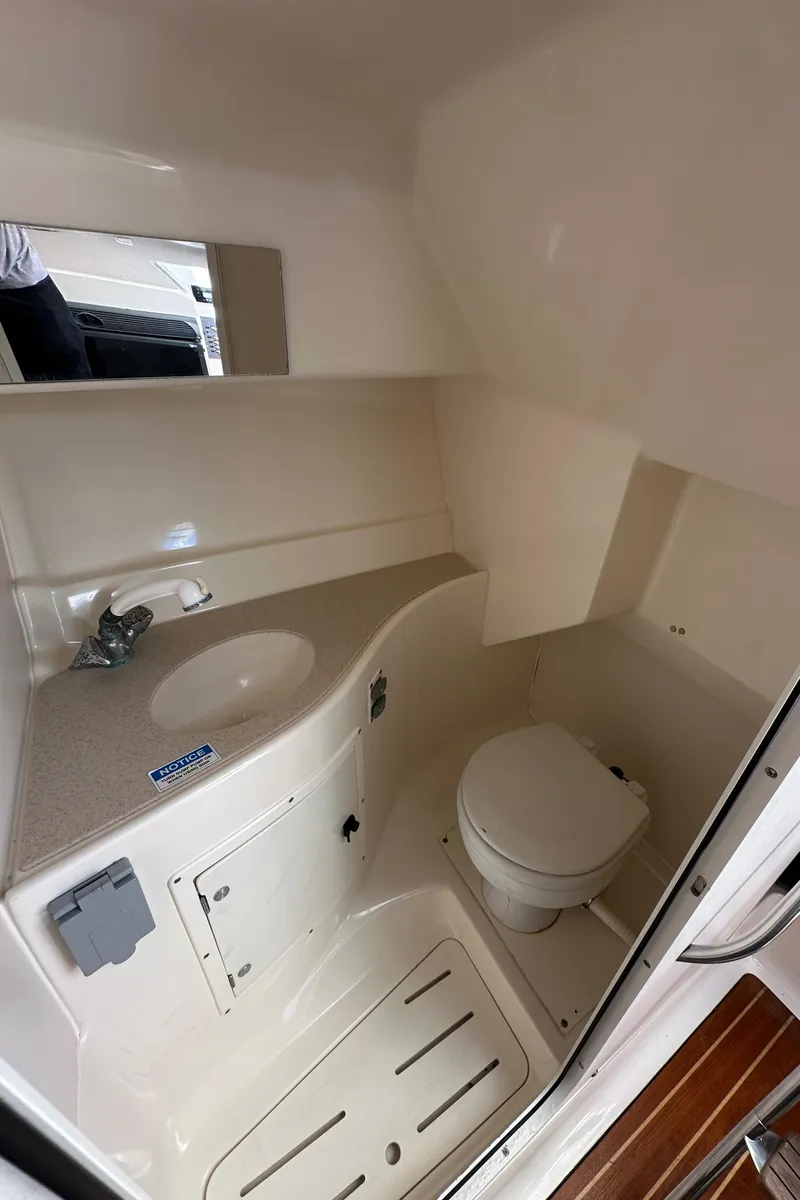 Slide: The Image of 2002 Pursuit 2860 Denali boat bathroom with sink, toilet, and mirror. - 37
