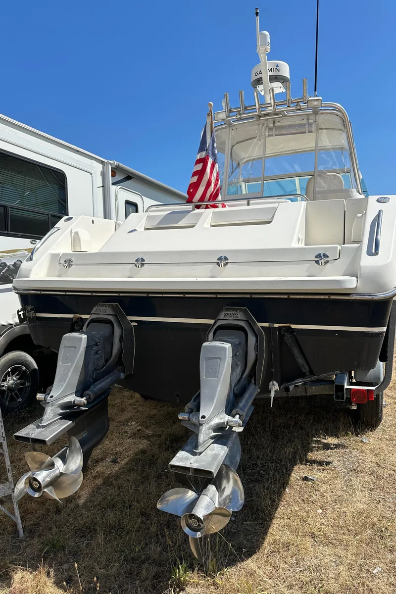 Slide: The Image of 2002 Pursuit 2860 Denali boat with dual propellers, parked on dry grass. - 41
