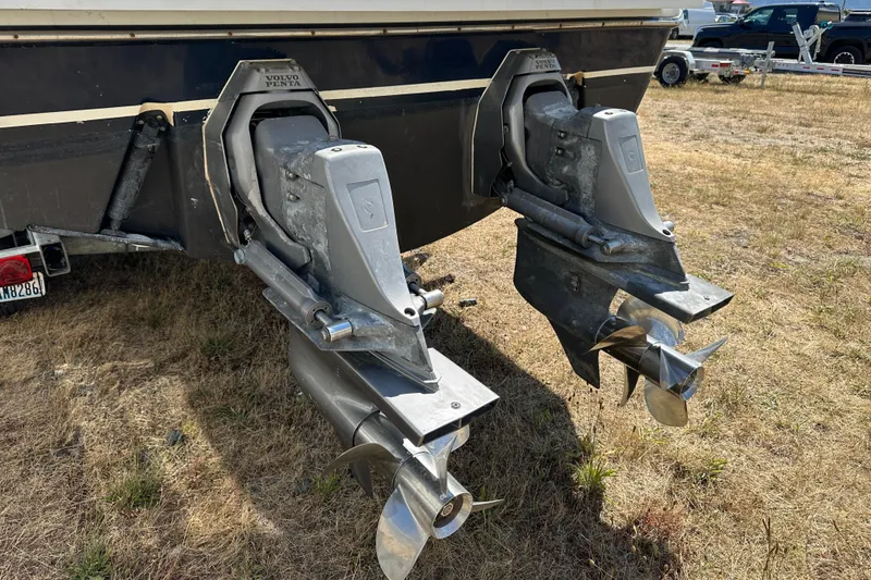 Slide: The Image of Twin Volvo Penta outdrives on a 2002 Pursuit 2860 Denali boat, parked on grass. - 42
