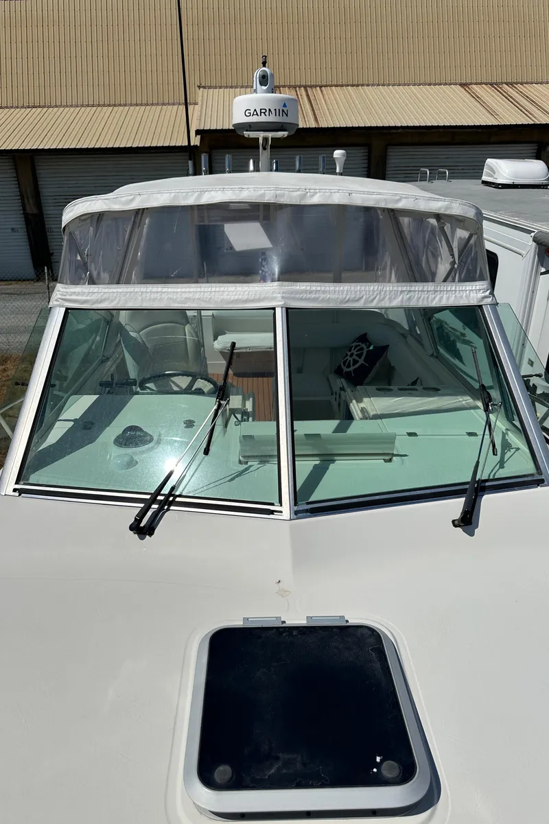 Slide: The Image of 2002 Pursuit 2860 Denali boat with Garmin radar, docked near industrial building. - 44