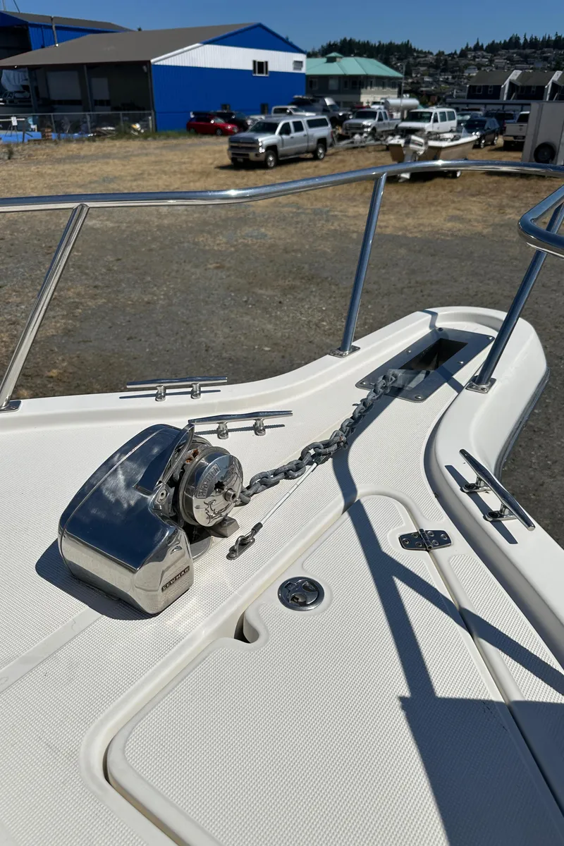Slide: The Image of 2002 Pursuit 2860 Denali boat deck with anchor chain and winch in a marina setting. - 47