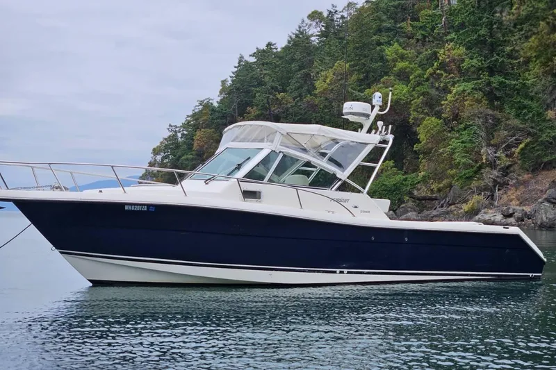 Slide: The Image of 2002 Pursuit 2860 Denali boat on calm water near forested shoreline. - 5