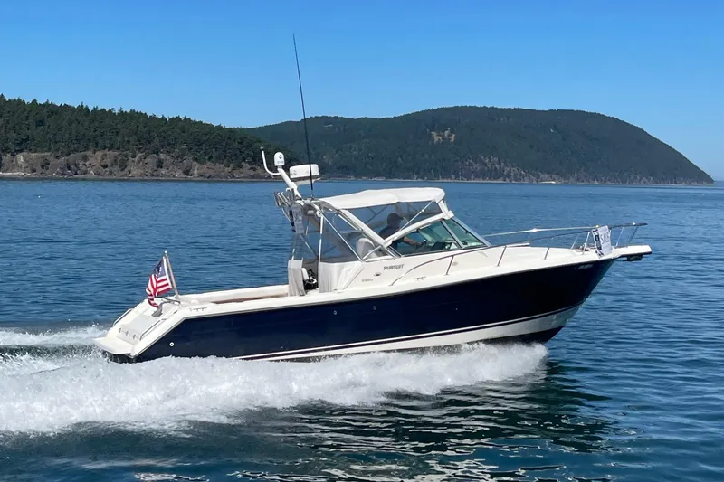Slide: The Image of 2002 Pursuit 2860 Denali boat cruising on blue water with scenic island backdrop. - 54