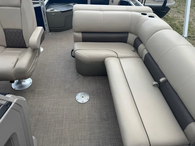 Slide: The Image of 2024 Sun Tracker Fishin' Barge 20 DLX interior with beige seating and cup holders. - 10