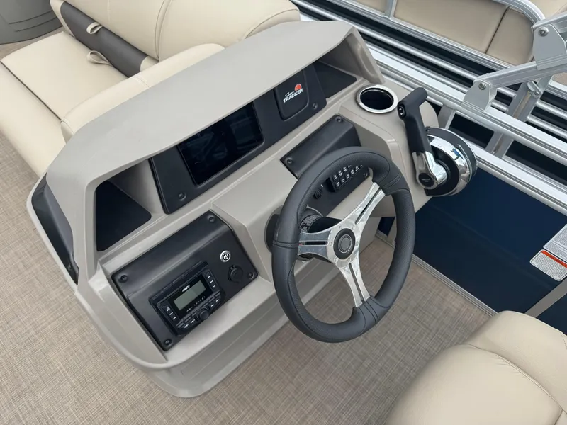 Slide: The Image of 2024 Sun Tracker Fishin' Barge 20 DLX steering console with modern controls and beige seating. - 12