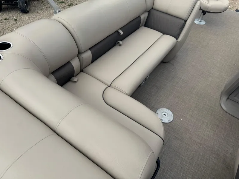 Slide: The Image of 2024 Sun Tracker Fishin' Barge 20 DLX interior with beige seating and carpeted flooring. - 16