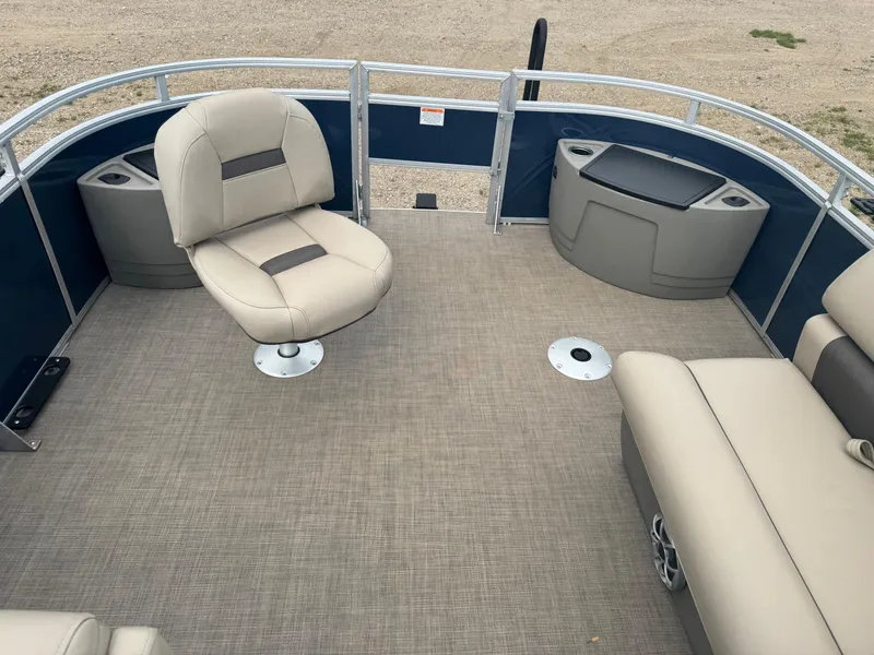 Slide: The Image of 2024 Sun Tracker Fishin' Barge 20 DLX interior with beige seating and spacious deck. - 18