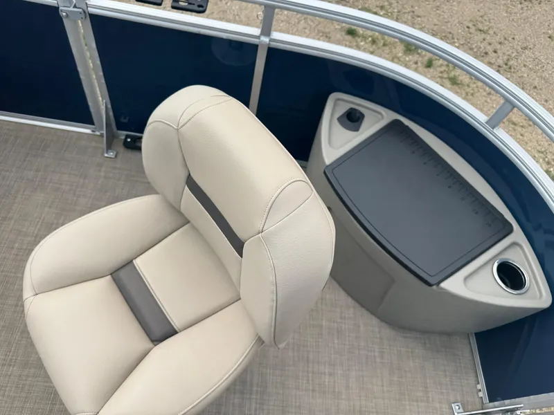 Slide: The Image of 2024 Sun Tracker Fishin' Barge 20 DLX interior with beige seating and fishing station. - 7