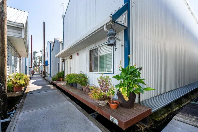 Slide: The Image of Custom Steelhead Boathouse 2006 with potted plants on a wooden deck by a walkway. - 2