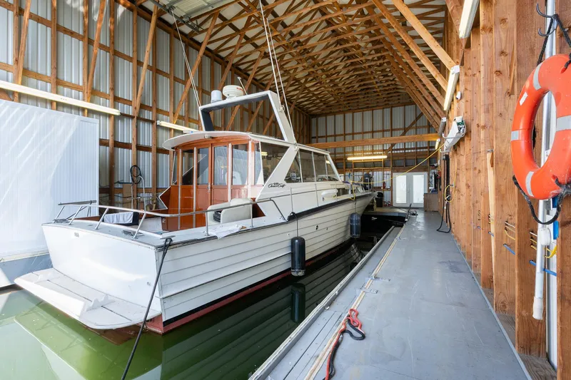 Slide: The Image of Custom Steelhead Boathouse 2006 with wooden interior, docked in a spacious boathouse. - 8
