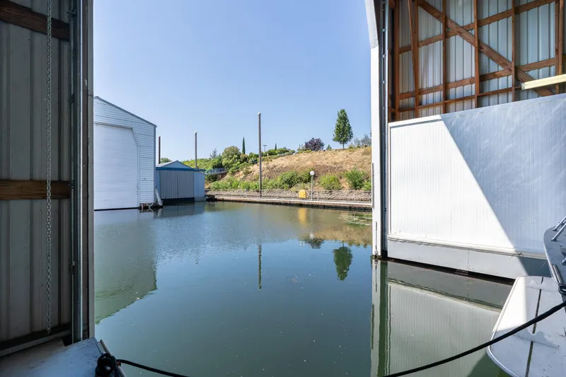 Slide: The Image of Custom Steelhead Boathouse, 2006, with open doors overlooking calm water and greenery. - 9