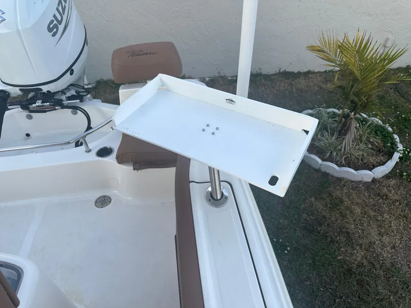 Slide: The Image of 2024 Pioneer 202 Sportfish boat with Suzuki engine and fishing accessory tray. - 18