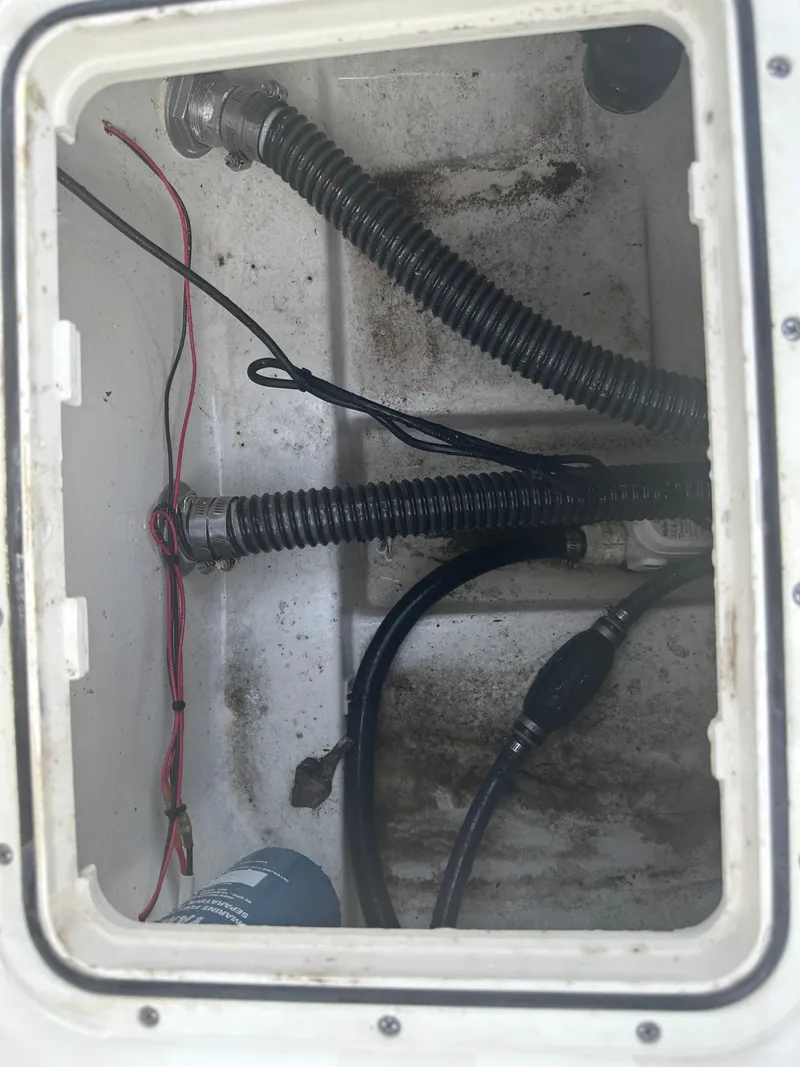 Slide: The Image of 2024 Pioneer 202 Sportfish boat compartment with hoses and wiring. - 22