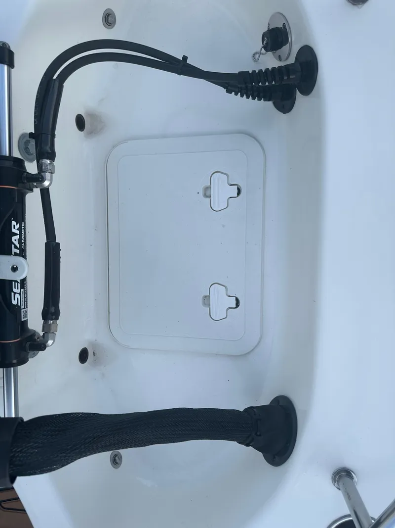 Slide: The Image of 2024 Pioneer 202 Sportfish boat interior with steering mechanism and storage compartment. - 23