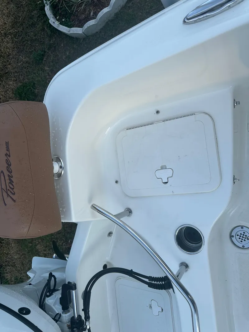 Slide: The Image of 2024 Pioneer 202 Sportfish boat interior with storage compartment and seating. - 25