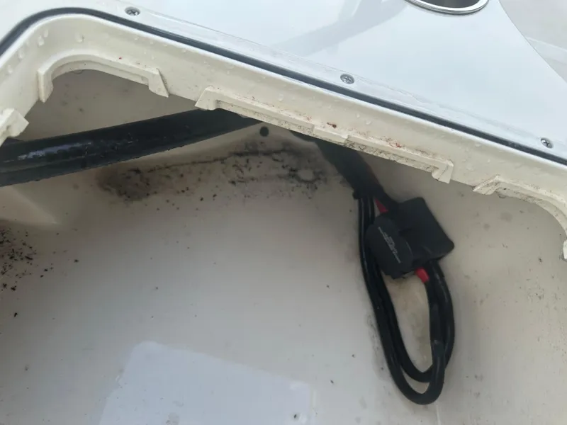 Slide: The Image of 2024 Pioneer 202 Sportfish boat compartment with wiring and slight dirt accumulation. - 26
