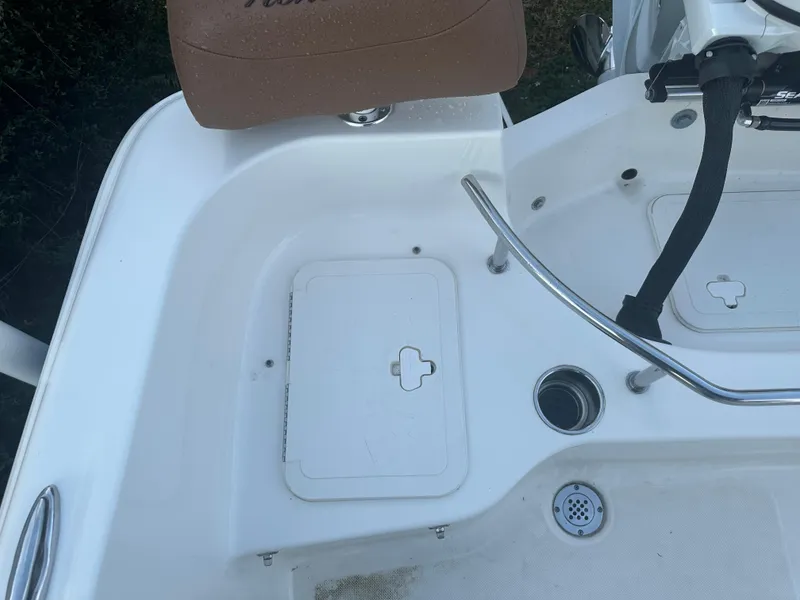 Slide: The Image of 2024 Pioneer 202 Sportfish boat deck with storage hatch and seating. - 28