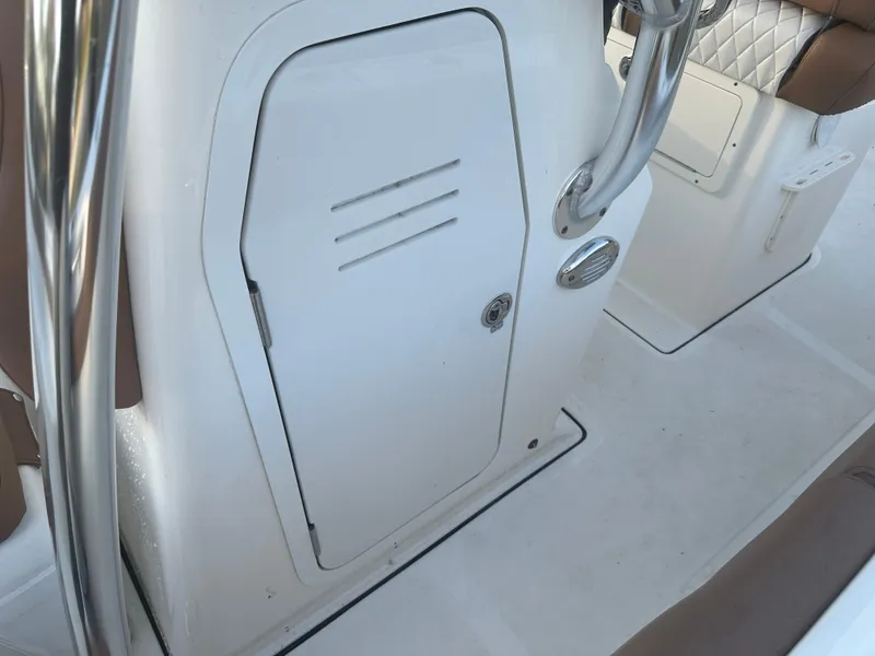 Slide: The Image of 2024 Pioneer 202 Sportfish boat interior, featuring a white storage compartment and stainless steel railing. - 37