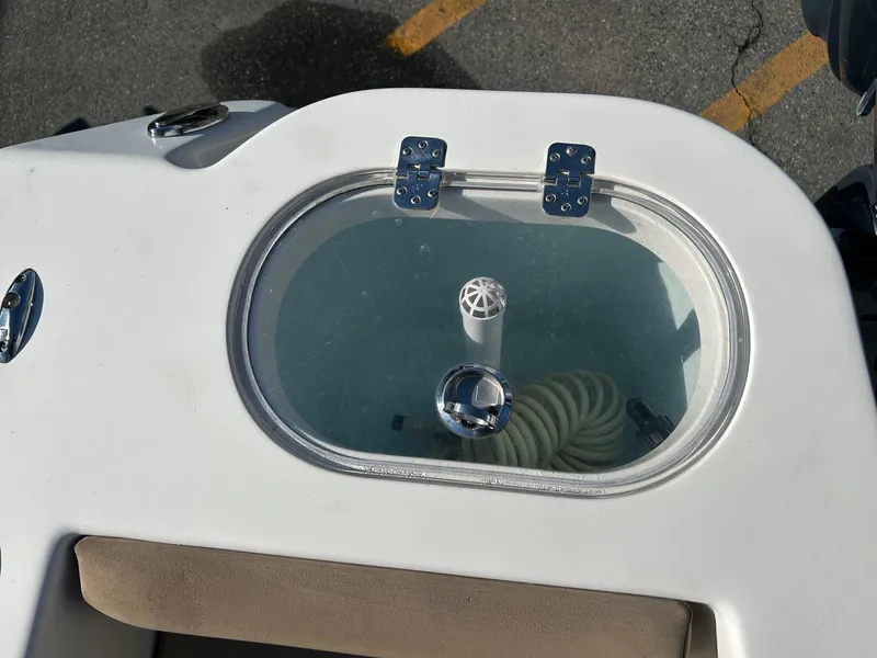 Slide: The Image of Livewell on 2020 Sailfish 220 WAC boat, featuring clear lid and coiled hose inside. - 15