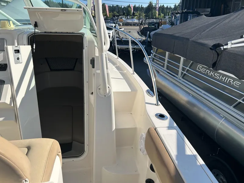 Slide: The Image of 2020 Sailfish 220 WAC boat interior with open cabin door and seating area. - 16