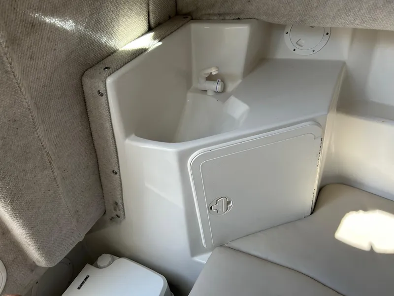 Slide: The Image of Interior of 2020 Sailfish 220 WAC boat, featuring storage compartment and seating area. - 17