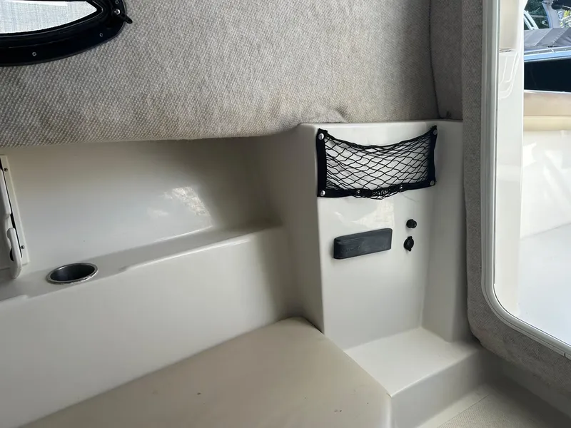 Slide: The Image of Interior of 2020 Sailfish 220 WAC boat, featuring seating and storage net. - 18