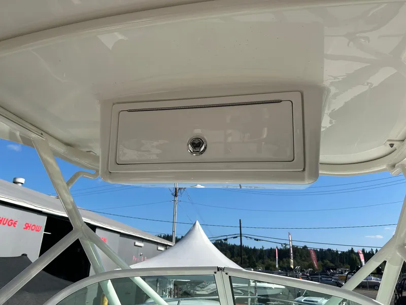 Slide: The Image of 2020 Sailfish 220 WAC boat interior with storage compartment under clear blue sky. - 22