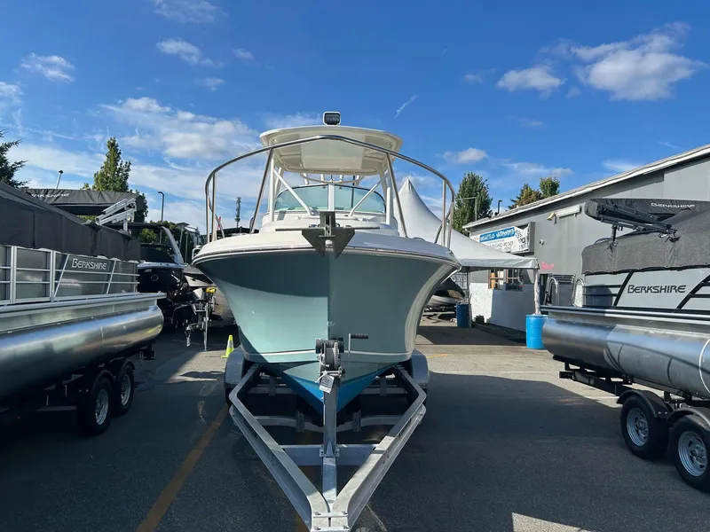 Slide: The Image of 2020 Sailfish 220 WAC boat on trailer, surrounded by other boats, under a clear blue sky. - 6