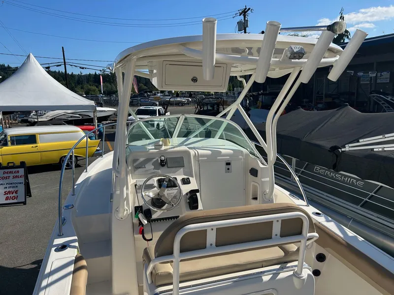 Slide: The Image of 2020 Sailfish 220 WAC boat interior with steering wheel and seating, displayed outdoors. - 8