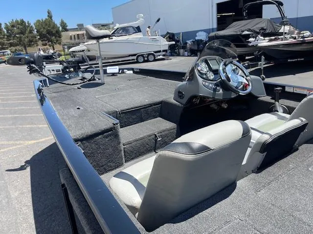 Slide: The Image of 2014 Lowe Stinger 18 HP boat with dual seats and steering console in a marina setting. - 10