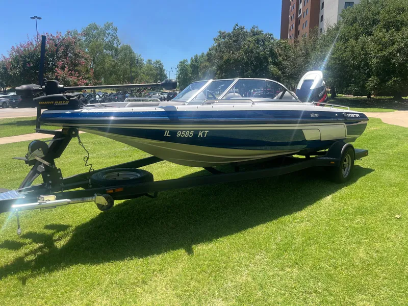 Slide: The Image of 2013 Skeeter SL190 boat on trailer, parked on grass in sunny park setting. - 8