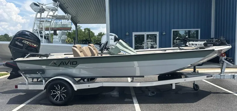 Slide: The Image of Avid 18 Vertex 2025 boat on trailer, parked outside a blue building. - 1