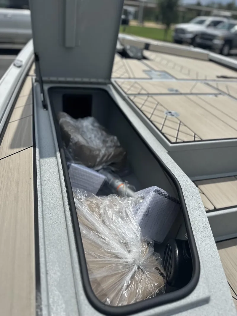 Slide: The Image of Storage compartment of 2025 Avid 18 Vertex boat, filled with packaged items. - 13