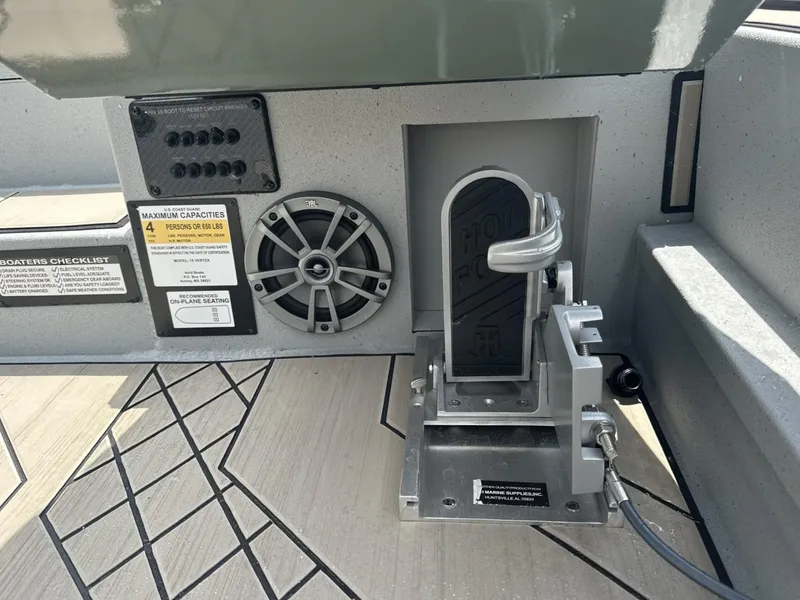 Slide: The Image of Boat interior with speaker, foot pedal, and capacity label on Avid 18 Vertex, 2025 model. - 18